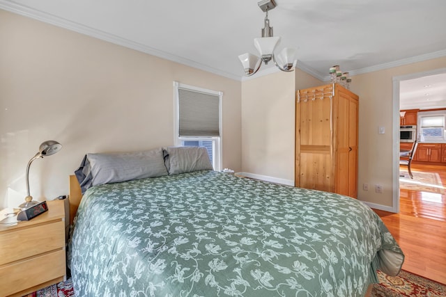 bedroom featuring hardwood / wood-style floors, ornamental molding, and a notable chandelier