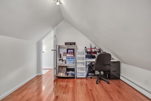 office area with baseboard heating, light hardwood / wood-style flooring, and vaulted ceiling