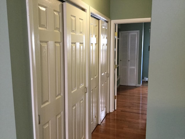 corridor with a barn door and dark hardwood / wood-style flooring