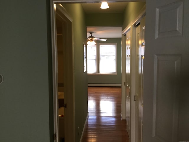 hall featuring a baseboard radiator and hardwood / wood-style flooring