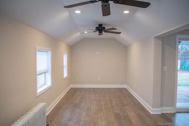 bonus room featuring hardwood / wood-style flooring, ceiling fan, lofted ceiling, and radiator