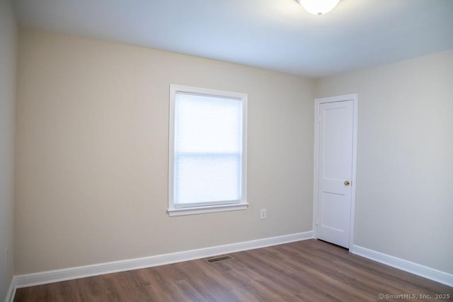 unfurnished room with dark hardwood / wood-style floors