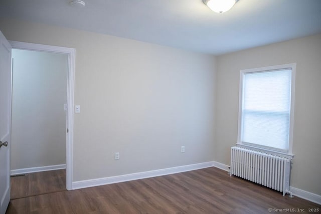 unfurnished room featuring dark hardwood / wood-style floors and radiator