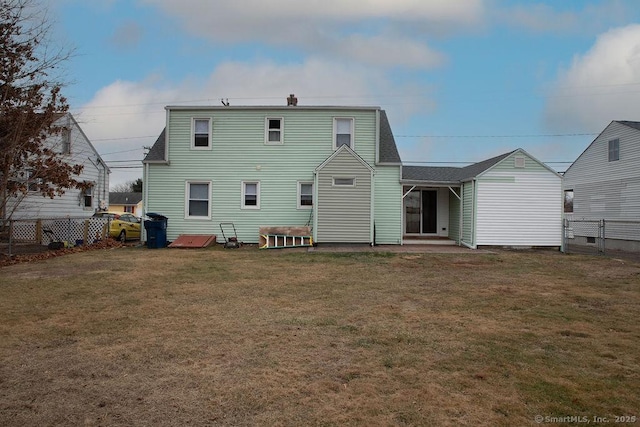 rear view of house featuring a lawn