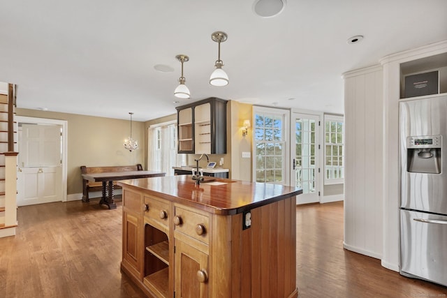 kitchen featuring pendant lighting, butcher block countertops, dark hardwood / wood-style floors, a center island, and stainless steel fridge with ice dispenser