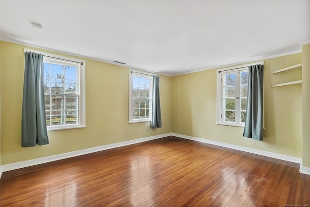 empty room featuring crown molding and hardwood / wood-style flooring