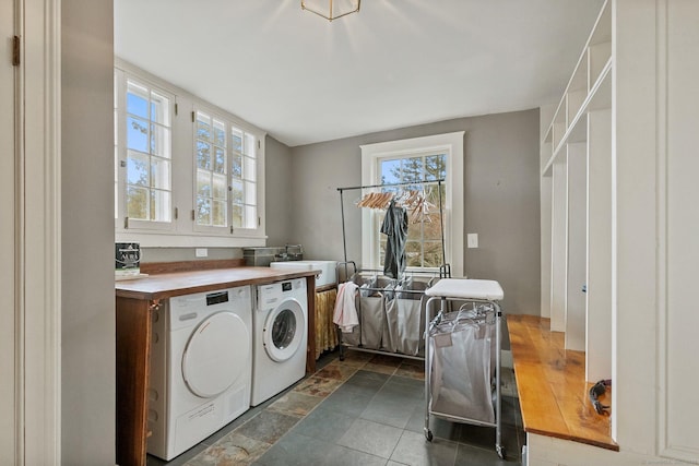 laundry area with separate washer and dryer and sink