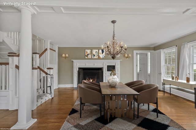 dining area with an inviting chandelier, crown molding, dark wood-type flooring, and ornate columns