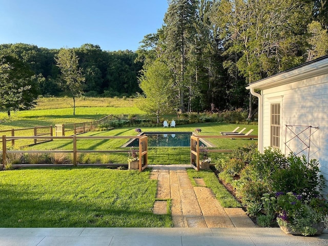 view of yard with fence and a fenced in pool