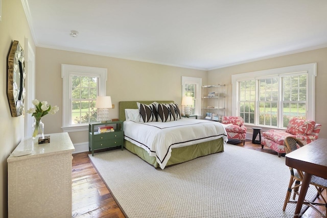 bedroom featuring baseboards, ornamental molding, and wood finished floors