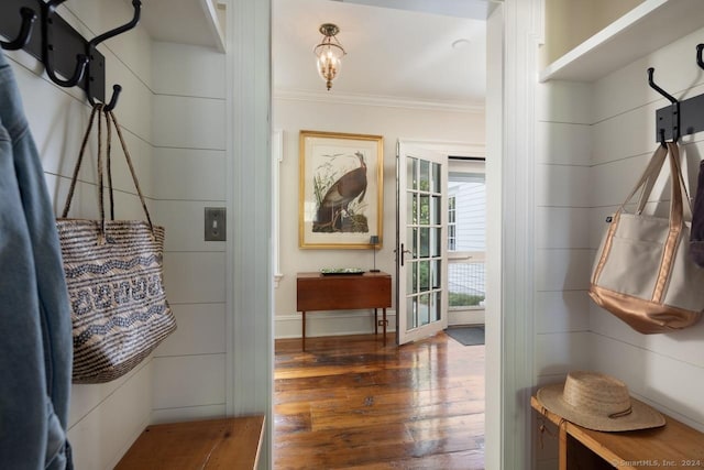 interior space featuring baseboards, crown molding, and wood finished floors