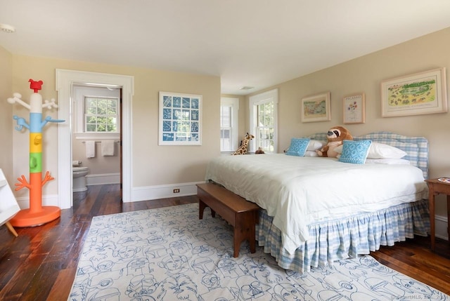 bedroom with ensuite bath, baseboards, and hardwood / wood-style flooring