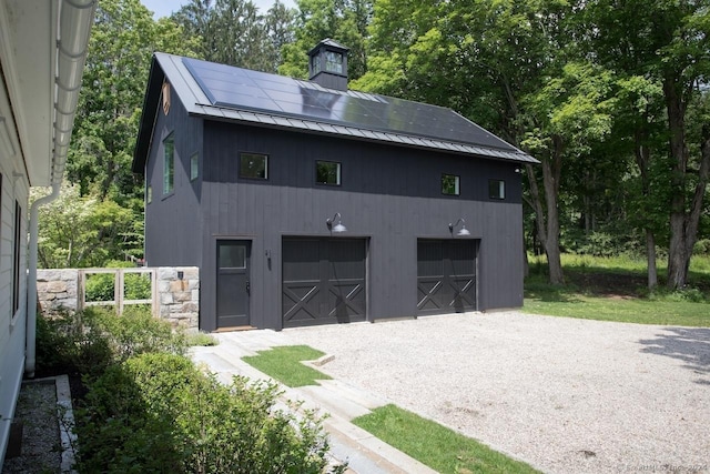 exterior space featuring metal roof, a standing seam roof, a chimney, and an outdoor structure