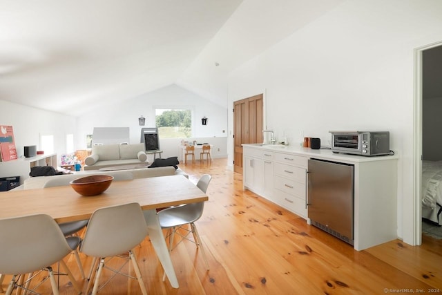 interior space featuring lofted ceiling, light wood-style floors, and a toaster