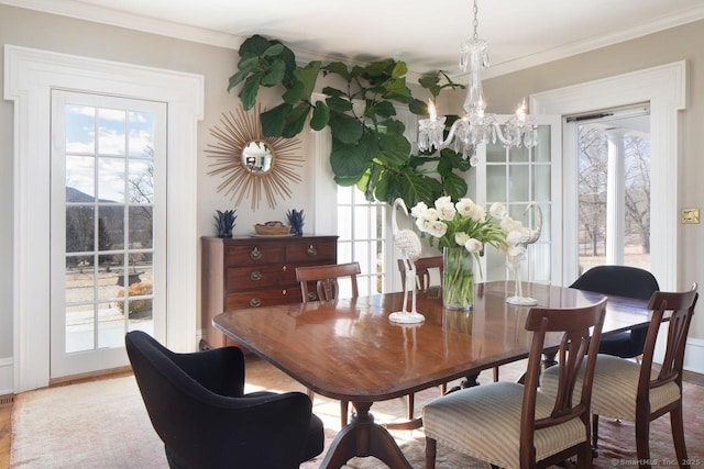 dining area with ornamental molding, a wealth of natural light, and a notable chandelier