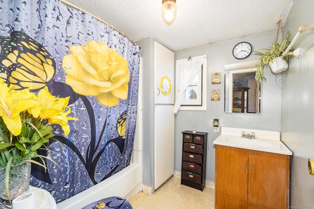 bathroom featuring vanity, shower / bath combo, and a textured ceiling