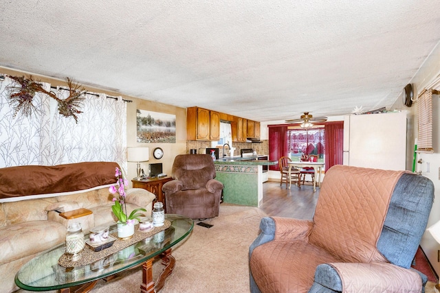 living room featuring ceiling fan and a textured ceiling