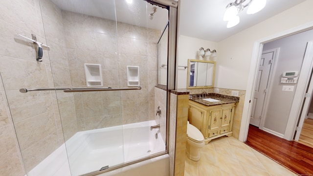 full bathroom featuring tile patterned flooring, vanity, toilet, and combined bath / shower with glass door