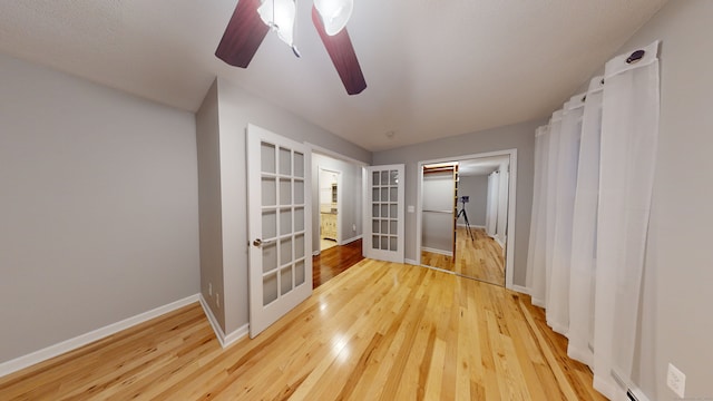 spare room featuring hardwood / wood-style flooring, ceiling fan, and french doors