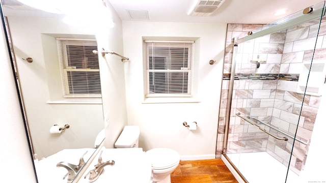 bathroom featuring toilet, hardwood / wood-style floors, and walk in shower