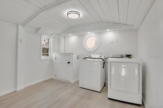 clothes washing area with washer and dryer, light hardwood / wood-style floors, and wood ceiling