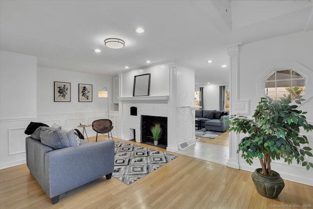 living room featuring a fireplace and light wood-type flooring