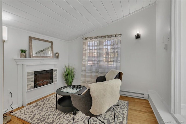 sitting room featuring light wood-type flooring, wooden ceiling, a baseboard radiator, and lofted ceiling