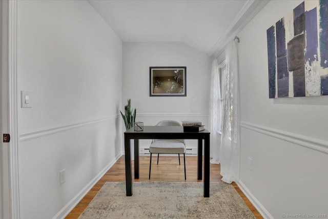 office featuring hardwood / wood-style floors, vaulted ceiling, and ornamental molding