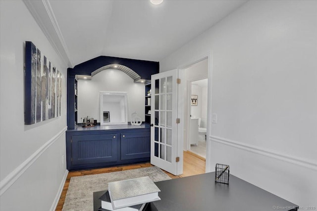 interior space with crown molding, vaulted ceiling, light hardwood / wood-style flooring, and blue cabinetry