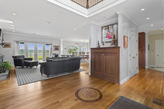 living area featuring light wood-style floors, visible vents, ornamental molding, and recessed lighting