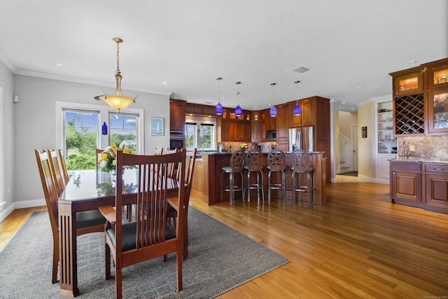 dining area with crown molding and hardwood / wood-style floors