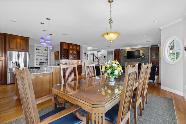 dining space featuring crown molding, recessed lighting, light wood-style flooring, baseboards, and stairs