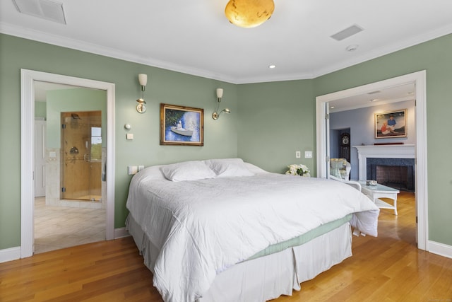 bedroom with light wood-style flooring, visible vents, and crown molding