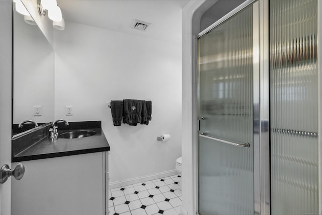 bathroom featuring toilet, a stall shower, visible vents, and vanity