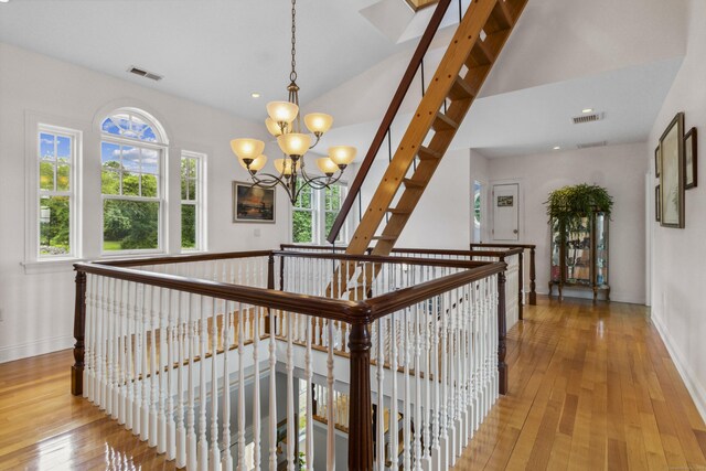 hall featuring a healthy amount of sunlight, visible vents, and light wood finished floors