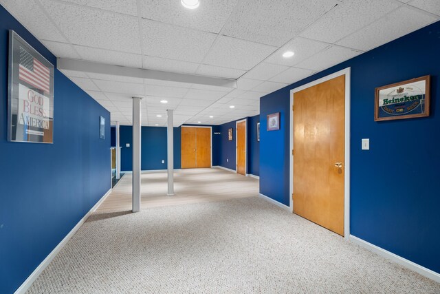 carpeted empty room featuring a drop ceiling, recessed lighting, and baseboards