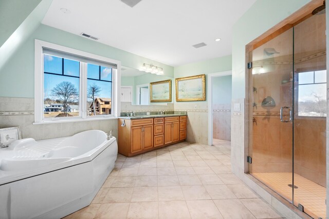 full bathroom with a garden tub, a shower stall, visible vents, and tile walls