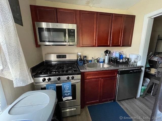 kitchen with stainless steel appliances, hardwood / wood-style flooring, and sink