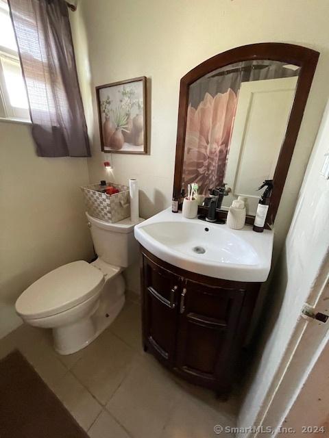 bathroom featuring tile patterned flooring, vanity, and toilet