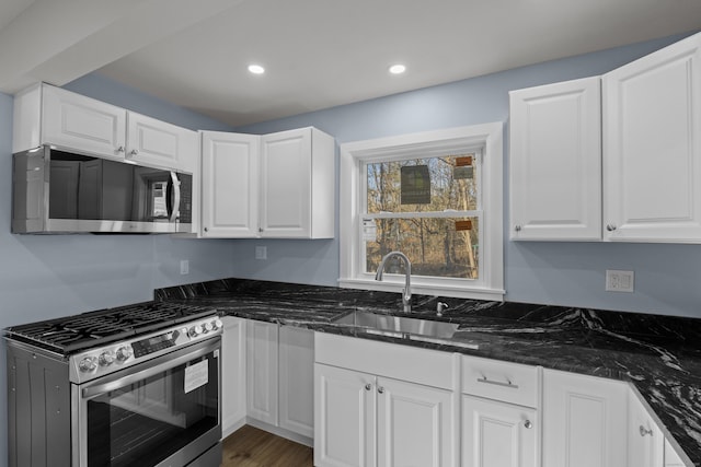 kitchen with white cabinets, dark stone countertops, sink, and appliances with stainless steel finishes