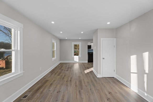 unfurnished living room with hardwood / wood-style floors and a healthy amount of sunlight