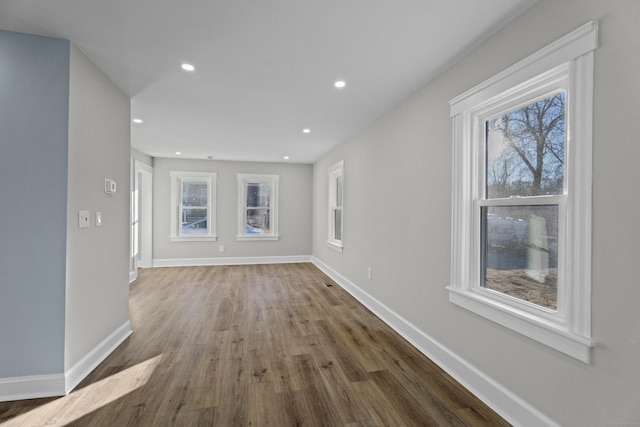 unfurnished living room featuring dark hardwood / wood-style flooring and plenty of natural light