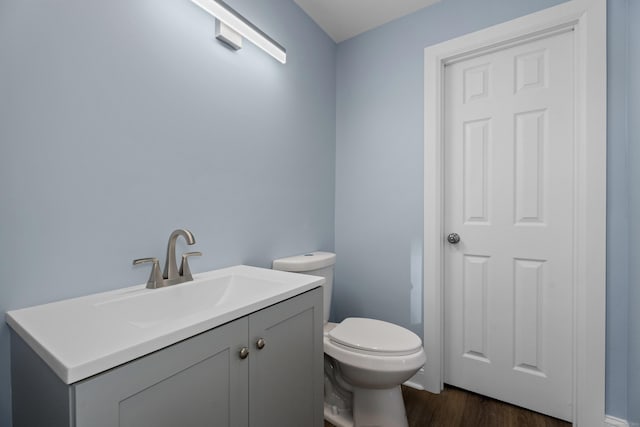 bathroom with vanity, wood-type flooring, and toilet