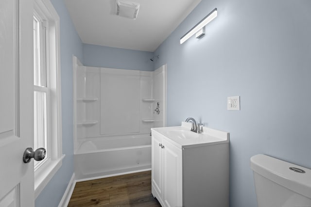 full bathroom featuring hardwood / wood-style floors, vanity, shower / bathtub combination, and toilet