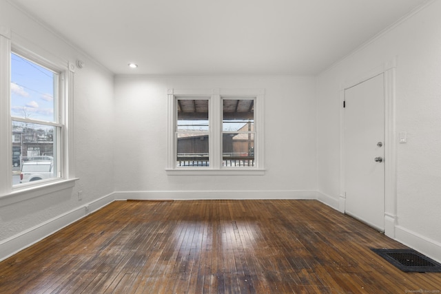 empty room with dark hardwood / wood-style floors and ornamental molding