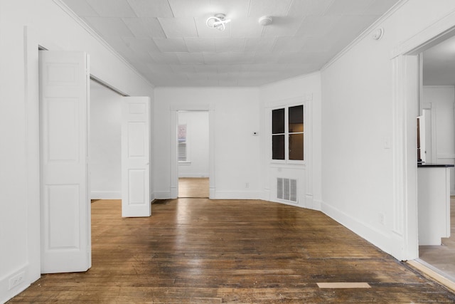 empty room featuring dark hardwood / wood-style flooring and ornamental molding