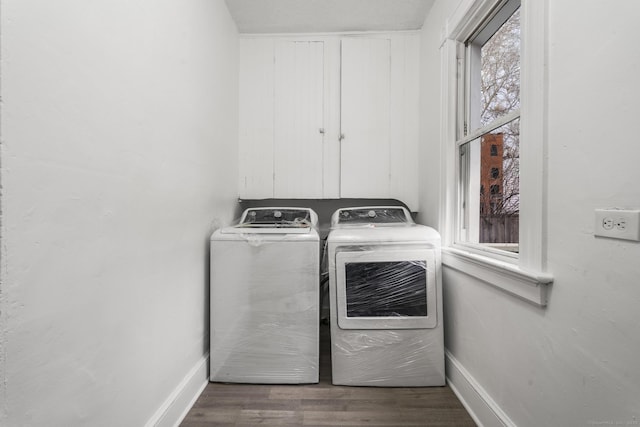 laundry room featuring independent washer and dryer, dark hardwood / wood-style flooring, and plenty of natural light