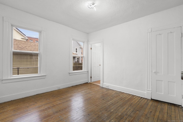 unfurnished room featuring a textured ceiling and dark wood-type flooring