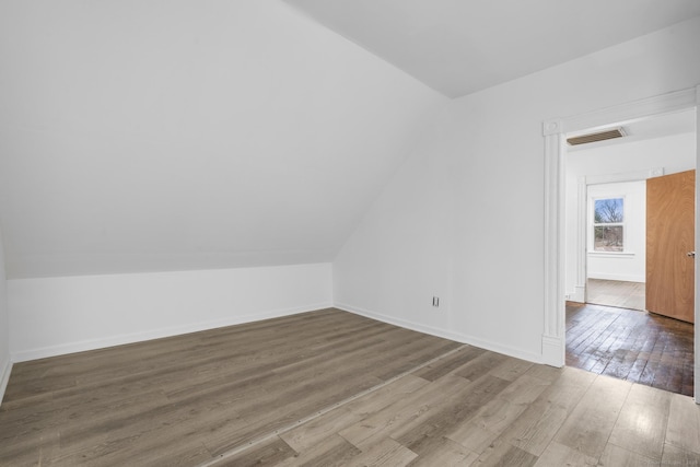 bonus room featuring wood-type flooring and vaulted ceiling