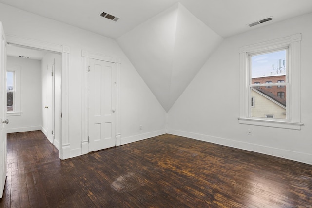 bonus room with dark hardwood / wood-style flooring and vaulted ceiling